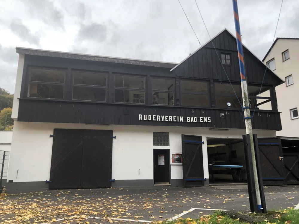 Das Bootshaus an der Mainzer Straße, unten weiß mit Hallentoren, oben dunkle Holzfassade mit Vereinsschriftzug